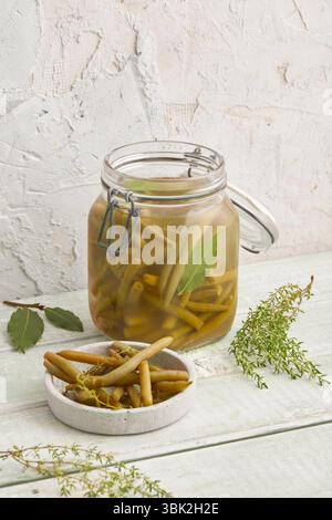 Eingelegte Bohnen, Walnüsse und Zwiebeln in einem Glas – ein herzhaftes hausgemachtes Konfitüre, perfekt für das Styling von Speisen, sauberes Essen, rustikale Küche oder Gärung Stockfoto