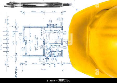 Gelber Helm eines Ingenieurs mit Plänen und Bogen Stockfoto