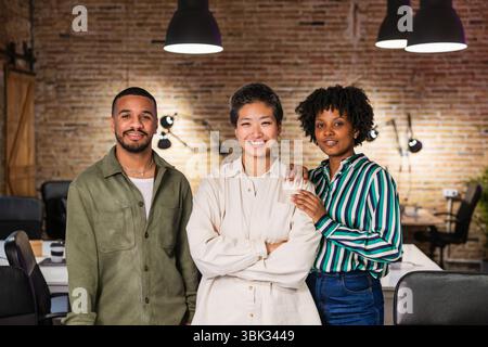 Multiethnisches Team lächelt und posiert im modernen Büro Stockfoto