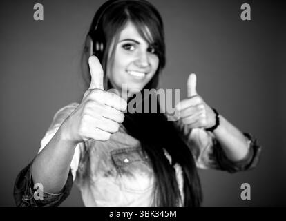 Frau, die im Studio Daumen nach oben zeigt Stockfoto