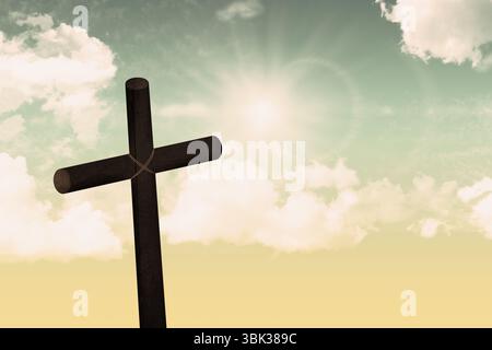 Einsames Holzkreuz steht vor leuchtendem Himmel mit Wolken und Sonnenstrahlen in flacher Bauweise Stockfoto