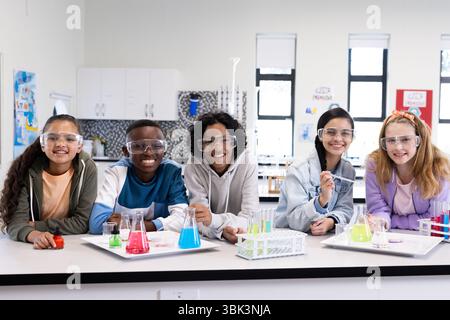 In der Schule experimentieren verschiedene Schüler mit bunten Flüssigkeiten im Unterricht Stockfoto