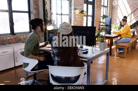 Verschiedene Frauen, die in modernen Büros an Programmierprojekten arbeiten, fokussiert und engagiert sind Stockfoto
