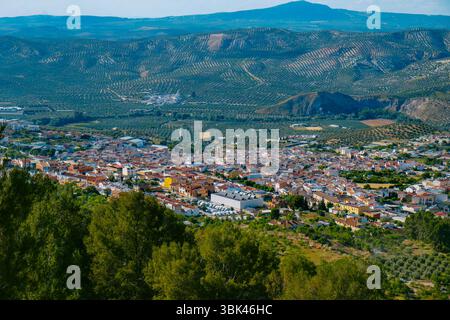 Ein Blick aus der Vogelperspektive auf Cuevas de San Marcos, eine kleine Stadt in der Provinz Malaga, Andalusien, Spanien, eingebettet zwischen Bergen und Olivenhainen an einem sonnigen Frühling Stockfoto