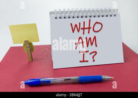 Wer bin ich auf einem Notizbuch auf rotem Hintergrund Stockfoto