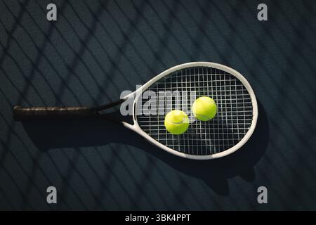 Flaches Design mit Tennisschläger, der auf dem Platz liegt, mit zwei Tennisbällen und einem Schattengitter aus Zaunzäunen Stockfoto