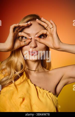 Eine junge Frau in lebendiger Kleidung schlägt eine verspielte Pose vor einem Hintergrund mit Gefälle. Stockfoto