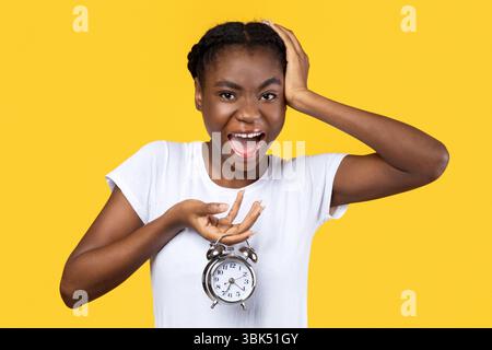 Schockiert Afrikanisch Amerikanische Frau Holding Uhr Posiert Über Gelben Hintergrund Stockfoto