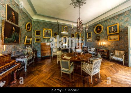 Salon in George Sands Haus in Nohant mit Porträts ihrer Vorfahren und Nachkommen. Das Anwesen Nohant ist noch immer untrennbar mit George Sand verbunden und mit vielen Originalstücken ausgestattet. Die meisten ihrer Werke (Romane, Märchen, Geschichten, Theaterstücke, Rezensionen, politische Artikel, autobiografische Texte und Briefe) wurden in Nohant geschrieben. Ab 1835 wurde George Sand politisch aktiv und kämpfte für sozialen Fortschritt und gleiche Rechte für Frauen. Das Haus kann nur im Rahmen einer Führung besucht werden. Place Sainte Anne, Nohant-Vic, Centre-Val de Loire, Frankreich Stockfoto