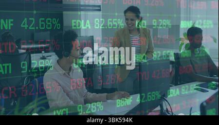 Lächelnde Frau im braunen Blazer mit Tablette, die Kollegen im Büro führt, mit Stock-Ticker-Overlay Stockfoto