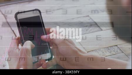 Halten Sie die Smartphone-Hülle und analysieren Sie überlagerte Aktienkarten auf einem Holztisch am Arbeitsplatz und im Kopierraum Stockfoto