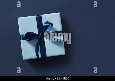 Blaue Geschenkbox auf marineblauem Hintergrund. Flache Lagen. Alles Gute Zum Vatertag. Grußkarte. Blick von oben. Kopierbereich. Stockfoto