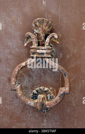 Ein alter schmiedeeiserner Türklopfer an der alten Holztür Stockfoto