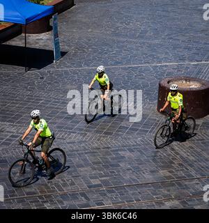 Iquique, Chile – 29. Januar 2025. Drei uniformierte Polizeibeamte (Carabineros) fahren auf einem Marktplatz in Iquique, Chile, mit dem Fahrrad. Stockfoto