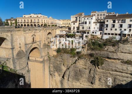 Die Steinbrücke Puente Nuevo aus dem 18. Jahrhundert überquert den El Tajo Canyon über den Fluss Guadalevin, die die neue Stadt und die Altstadt von Ronda in Spanien verbindet. Die vom Architekten José Martin de Aldehuela entworfene Brücke dauerte 34 Jahre und überspannte eine 390 Meter lange Schlucht. Stockfoto