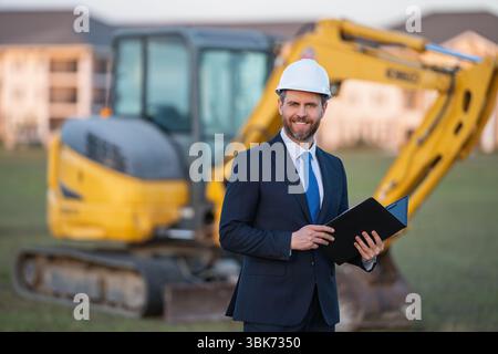 Buider-Mann in Anzug und Schutzhelm. Bauinvestor. Geschäftsmann-Investor vor der Baustelle. Erfolgreicher Investor. Ein hübscher Mann im Anzug Stockfoto
