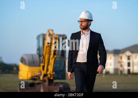 Buider-Mann in Anzug und Schutzhelm. Bauinvestor. Geschäftsmann-Investor vor der Baustelle. Erfolgreicher Investor. Ein hübscher Mann im Anzug Stockfoto