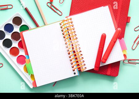 Verschiedene Schreibwaren und Notizbücher auf türkisfarbenem Hintergrund Stockfoto