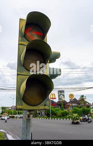 Bali, Indonesien - 25. Dezember 2024: Eine Ampel mit einem roten Pfeil leuchtet auf, um anzuzeigen, dass die Fahrer nach links abbiegen sollten. Das Licht ist rot, was bedeutet Stockfoto