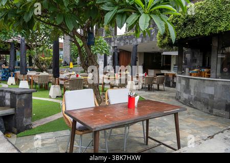 Bali, Indonesien - 25. Dezember 2024: Terrasse des Restaurants mit Tisch und Stühlen. Der Tisch ist leer und die Stühle sind leer Stockfoto