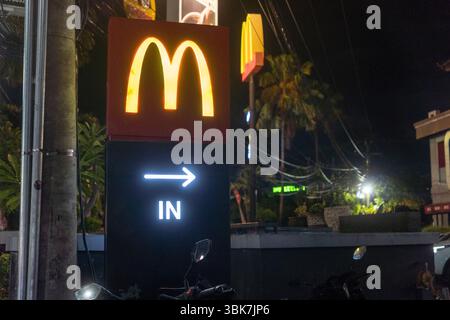 Bali, Indonesien - 25. Dezember 2024: McDonald's Restaurant mit einem Mcafe an der Seite. Das Restaurant ist nachts beleuchtet Stockfoto