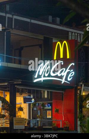 Bali, Indonesien - 25. Dezember 2024: McDonald's Restaurant mit einem Mcafe an der Seite. Das Restaurant ist nachts beleuchtet Stockfoto