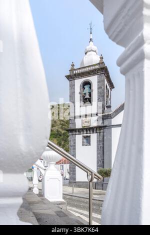 Historischer Kirchenglockenturm eingerahmt von weißen Brüstungen der nahegelegenen Treppen in Velas Stadt, Sao Jorge Island. Azoren Architektur, Portugiesisches Religiöses Bui Stockfoto