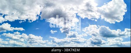 Weitläufiger blauer Himmel mit flauschigen weißen Wolken, die eine ruhige und ruhige Atmosphäre schaffen und die Schönheit der Natur und die Weite des offenen Himmels zeigen Stockfoto