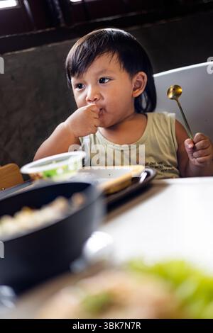 Kleinkind isst Frühstück alleine, Hintergrund für Werbung und Tapeten in der Food and Drink Lifestyle Szene. Stockfoto