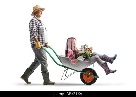 Reifer Mann, der eine junge Frau mit Blumen in einer Schubkarre schießt, isoliert auf weißem Hintergrund Stockfoto