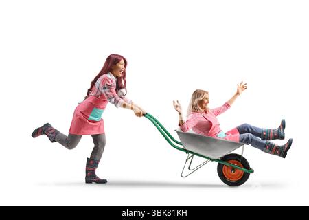 Reifer Mann, der eine junge Frau mit Blumen in einer Schubkarre schießt, isoliert auf weißem Hintergrund Stockfoto