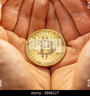 Physische Bitcoin in den Händen gehalten Nahaufnahme Stockfoto