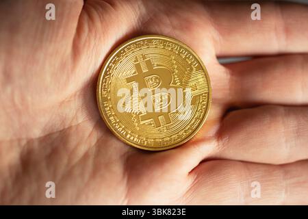 Physische Bitcoin in den Händen gehalten Nahaufnahme Stockfoto