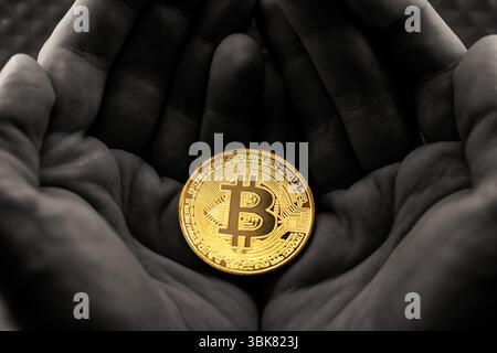 Physische Bitcoin in den Händen gehalten Nahaufnahme Foto in selektiven Farben Stockfoto