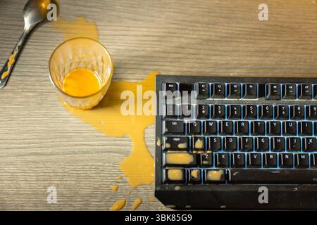 Kaffee ist auf die mechanische Tastatur der Computernähe verschüttet Stockfoto