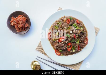 Bulgogi ist ein koreanisches Gericht, das aus Rindfleisch mit Sauce und Gewürzen gegrillt wird. Auf weißem Hintergrund Stockfoto