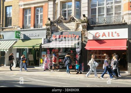 London Souvenirs Shop (am ehemaligen Südeingang der St. Anne's Church) und Touristen auf der Shaftesbury Avenue, Londons West End, England Großbritannien. Souvenirläden Stockfoto