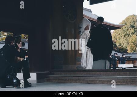 Ein Paar in traditioneller Hochzeitskleidung wird während einer Shinto-Zeremonie im Meiji Jingu-Schrein fotografiert Stockfoto