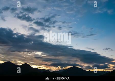 Panoramablick auf die Silhouetten der Berge unter dem Morgenhimmel in Pastel Stockfoto