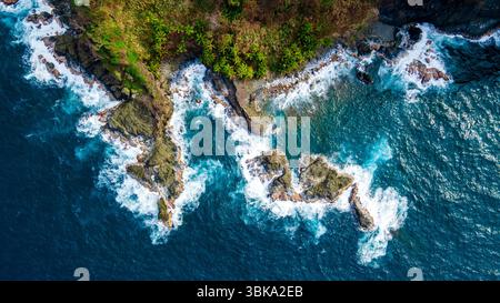 Atemberaubender Blick aus der Vogelperspektive auf die zerklüftete Küste von Sapzurro, Choco, Kolumbien, mit üppigem Grün und rauschenden Wellen. Stockfoto