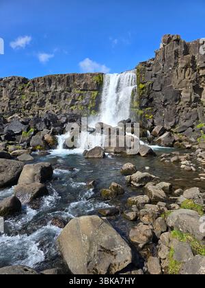 Das Wasser stürzt gewaltig über felsige Felsvorsprünge an einem atemberaubenden Wasserfall im Thingvellir-Nationalpark. Oxarfoss Wasserfall Island Stockfoto