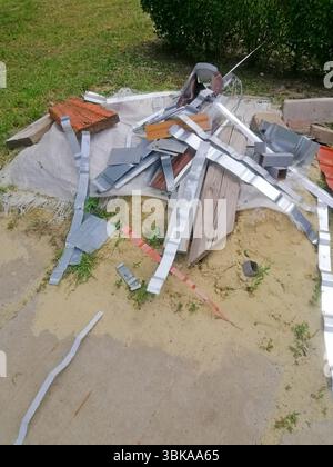 Metall-, Holz- und Kunststoffreste aus Bauarbeiten, die in Unordnung liegen, Baumüll, Stadtreinigung im Gange sind. Beschädigte Baumaterialien Stockfoto