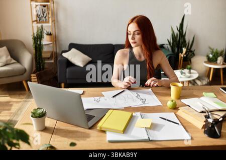 Die schöne junge Frau sitzt an einem Holztisch und konzentriert sich auf ihre Skizzen und Ideen. Stockfoto