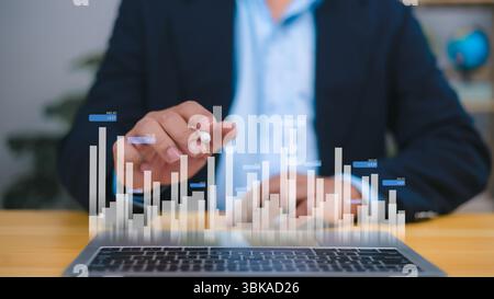 Ein Geschäftsmann analysiert ein holografisches Balkendiagramm über einem Laptop, Finanzwachstum, Marktanalysen und datenbasierte Entscheidungen. Geschäftserfolg, Inv Stockfoto