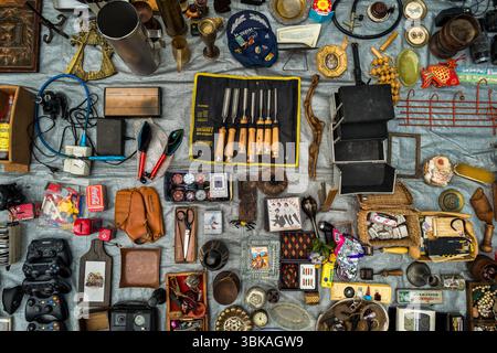 Eine Mischung aus Antiquitäten, Vintage-Werkzeugen, Haushaltsgegenständen und Sammlerstücken wird auf einer Plane auf einem Straßenmarkt in Montevideo, Uruguay, ausgestellt. Stockfoto