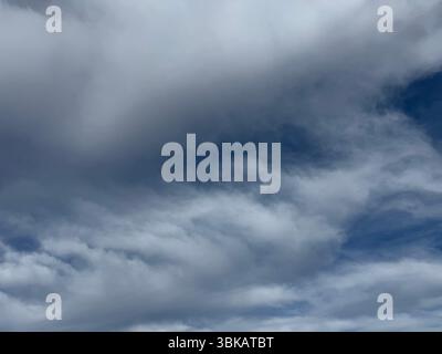 Mehrschichtige Altocumulus-Wolken bedecken den Himmel mit strukturierten Mustern und sanften Schatten. Stockfoto