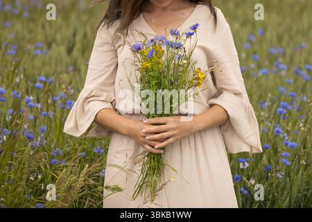 Eine Frau, die Wild Kräuter Bouquet in Meadow hält Stockfoto
