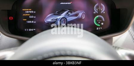 Dashboard-Ansicht eines McLaren 570S Sportwagens mit digitalem Display, das Fahrzeuginformationen anzeigt. Stockfoto