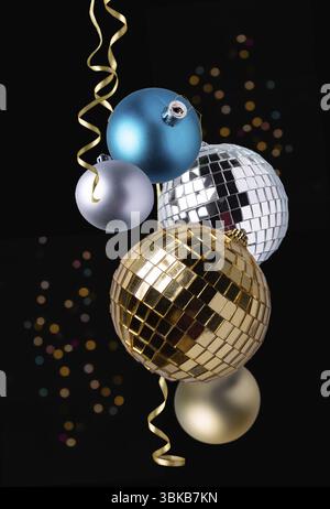 Goldene und silberne weihnachtskugeln, Bokeh und Serpentinen auf dunklem Hintergrund, weihnachtliche Einrichtung Stockfoto
