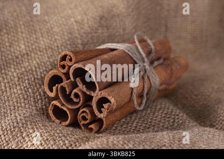Zimtstangen mit Garn auf einem groben Tuch gebunden Stockfoto